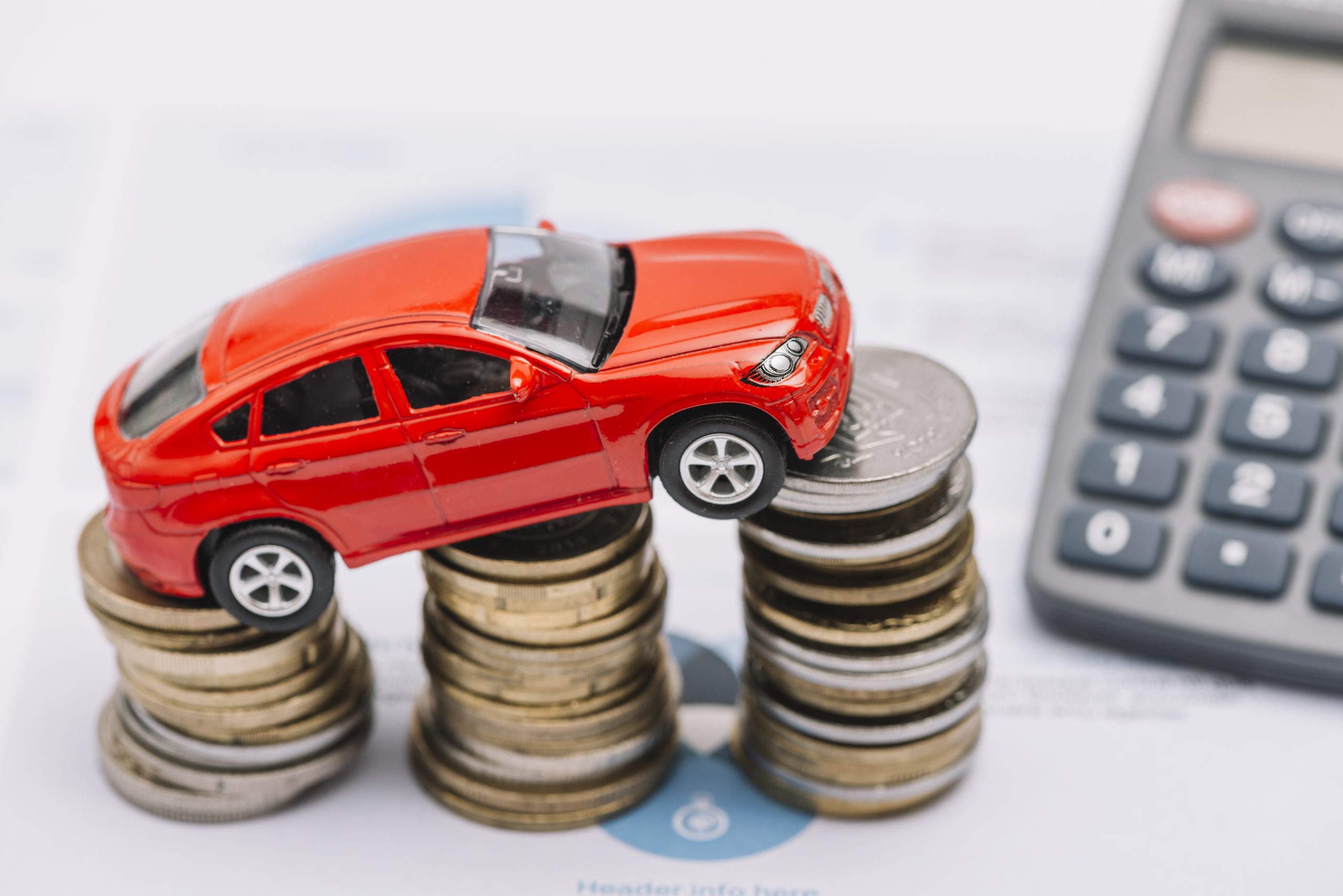red toy car placed on top of stacked coins
